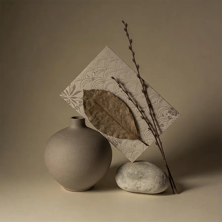 Composition de ressources naturelles Maison Takehana avec céramique grise, papier washi, feuille sèche et galet clair